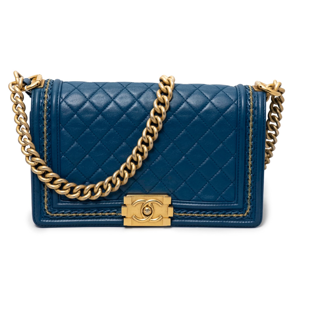 Blue quilted Chanel handbag with gold chain and clasp on a white background