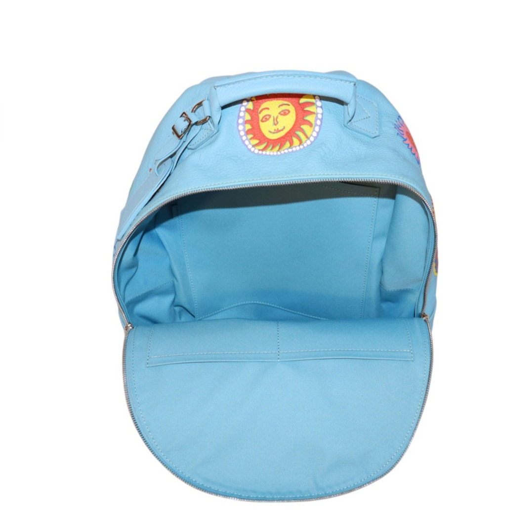 A Louis Vuitton - LV x Kusama Backpack light blue shown from the front, featuring a top handle, a zippered main compartment, and a yellow sun graphic patch on the upper front.