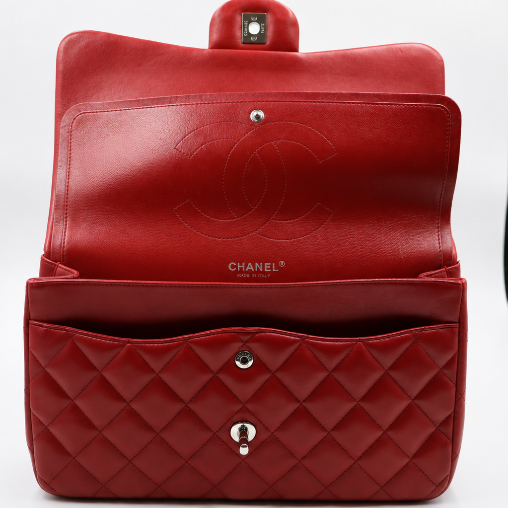 open view red Chanel shoulder bag made of quilted leather, shown open to display the interior and the embossed Chanel logo on the inside flap.