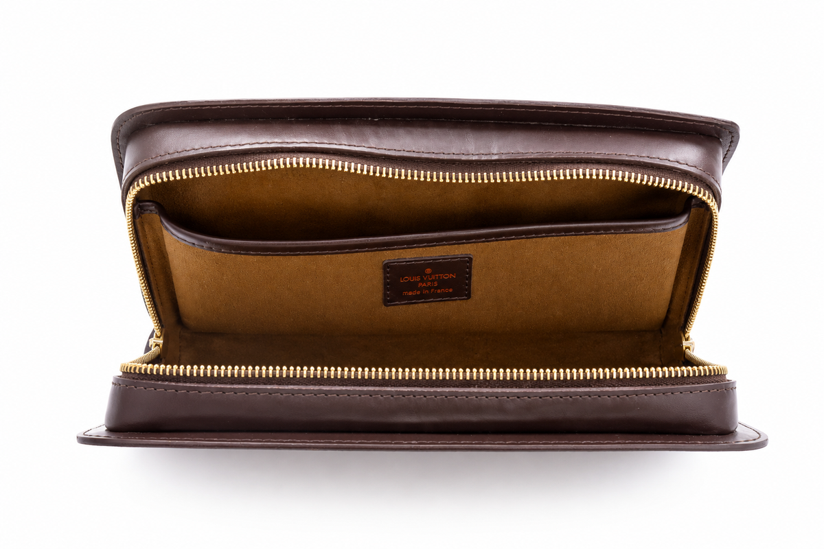 A dark brown Louis Vuitton leather zip-around clutch shown open, displaying a tan interior lining and gold-tone zippers. A small brown leather brand patch is visible inside.