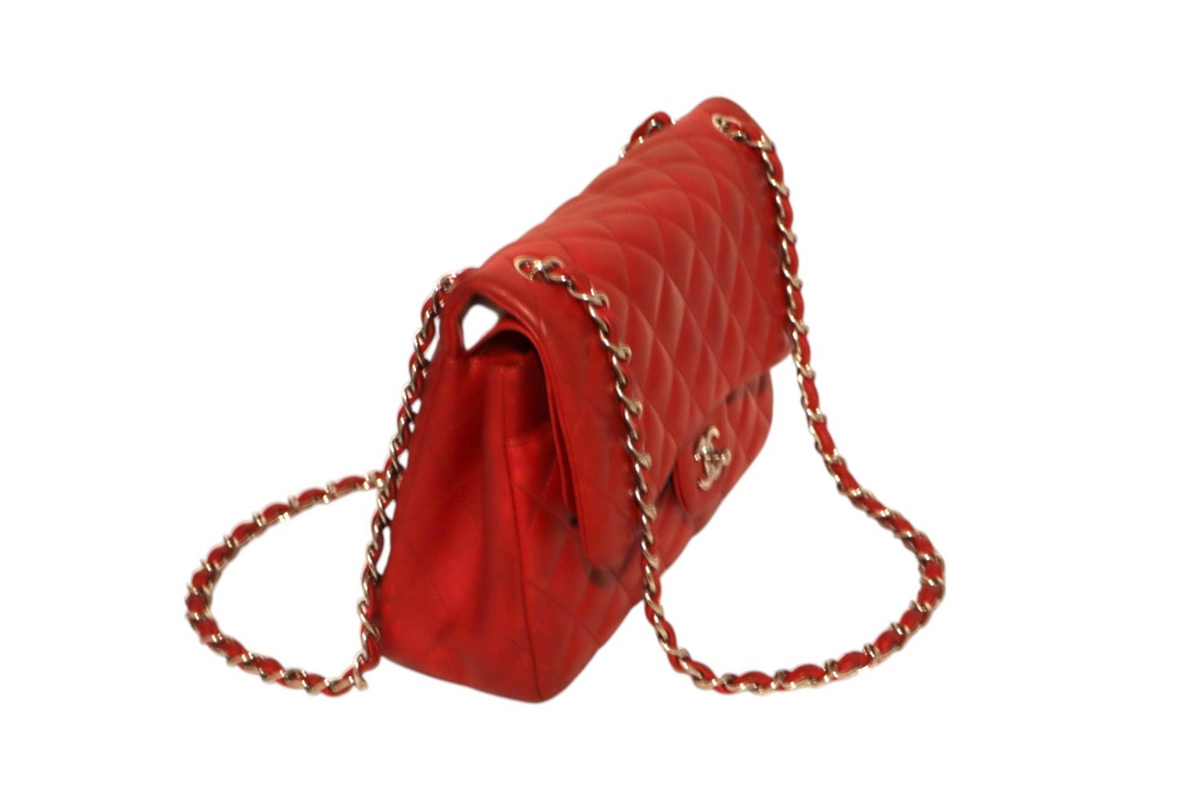 A red quilted Chanel leather shoulder bag with a gold-tone chain strap, shown from a side angle.