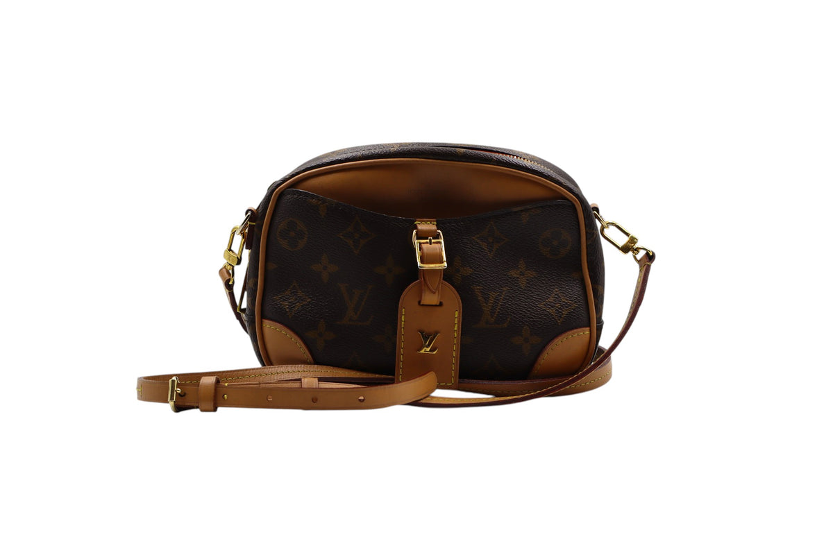front view Louis Vuitton monogram canvas shoulder bag with tan leather trim and strap, featuring a front leather tab with a gold-tone LV logo, set against a plain white background.