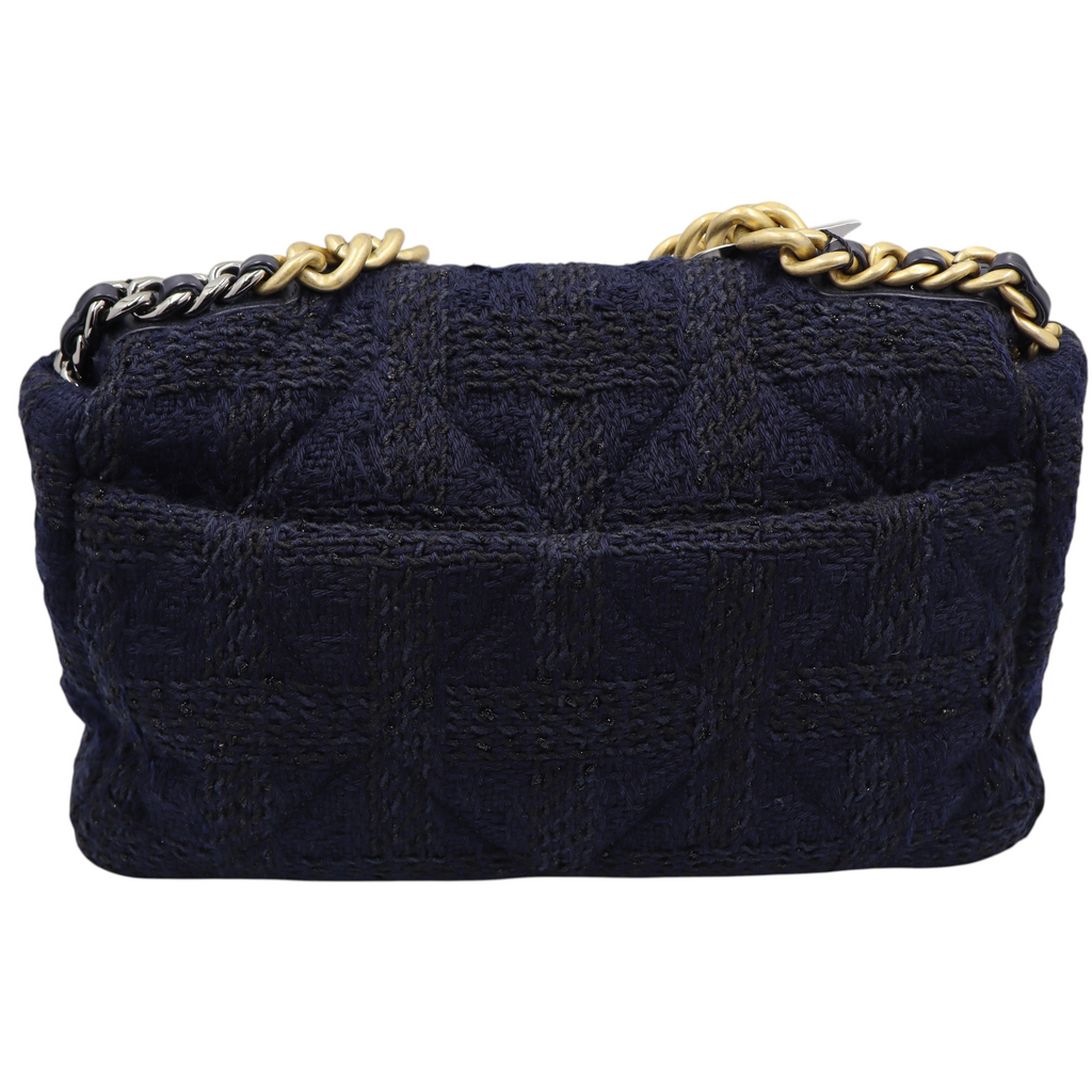 Back view of a navy blue Chanel quilted tweed shoulder bag with a gold and silver chain strap.