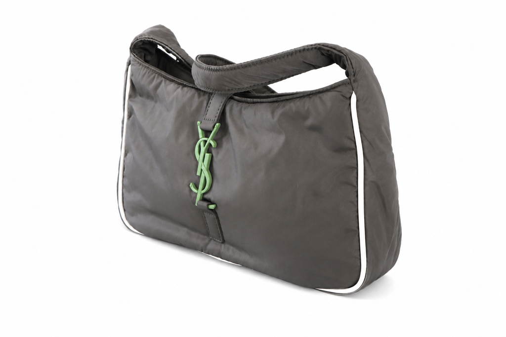 Yves Saint Laurent dark gray nylon shoulder bag with white piping and a green YSL monogram charm, shown on a white background.