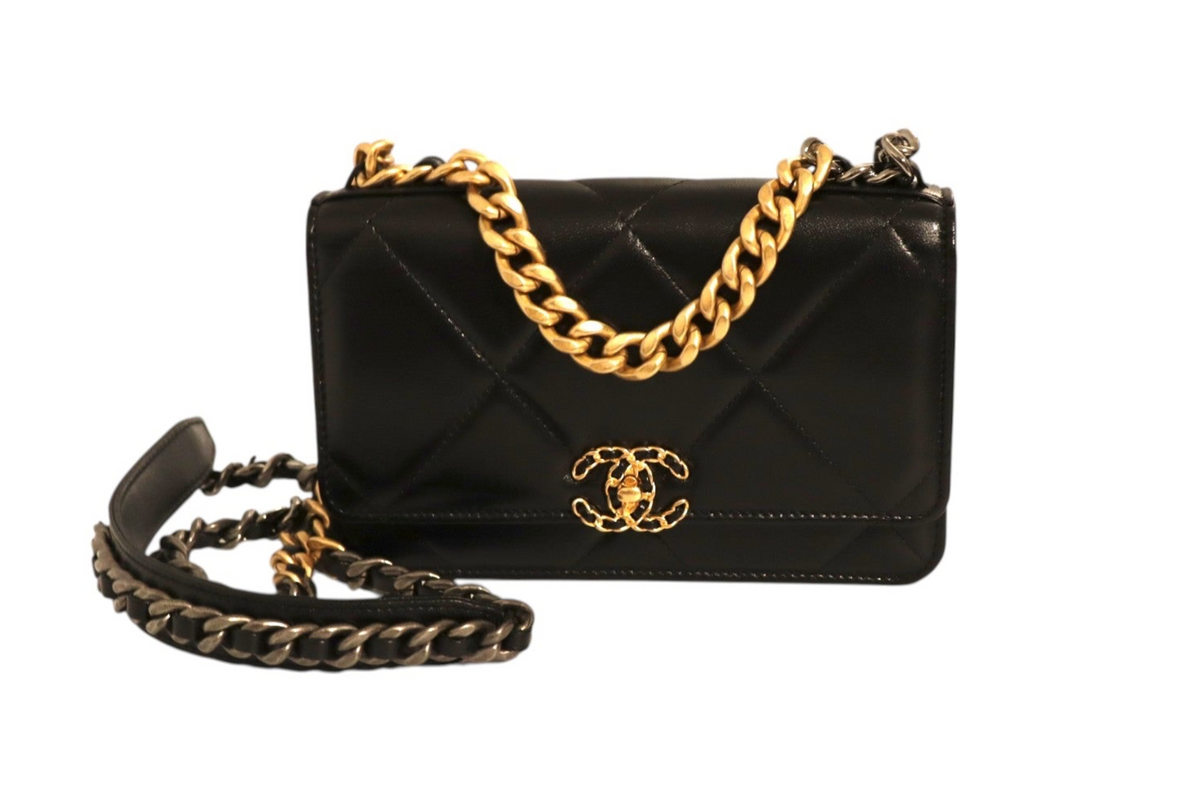 Front view of Chanel black quilted leather flap bag with gold-tone CC logo, chunky gold chain detail, and mixed-metal chain shoulder strap