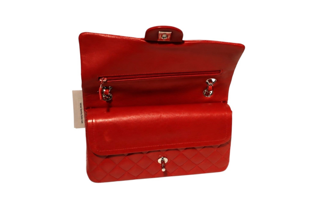 A Chanel red quilted leather handbag shown open, displaying its interior pocket and silver-tone hardware.