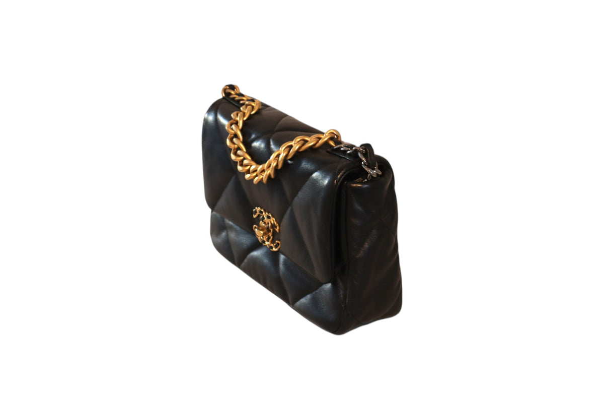 Side view of black quilted Chanel flap bag  with gold hardware.